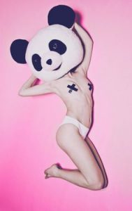 topless girl jumps in a panda mask